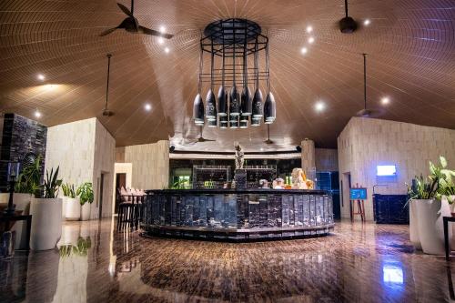 a lobby with a bar in a building at The Sakala Resort Bali All Suites in Nusa Dua