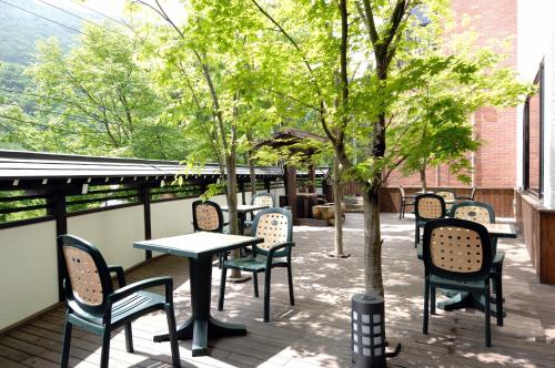a group of chairs and tables and trees on a patio at Hodakaso Yamano Hotel in Takayama