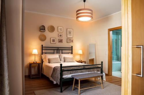 um quarto com uma cama, uma cadeira e um candeeiro em Sovipral Homes Casa Marina em Olhão
