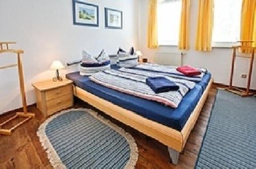 um quarto com uma cama grande com lençóis e almofadas azuis em Meeresrauschen - a72292 em Neuhaus