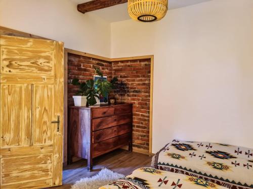 Cette chambre est dotée d'une porte en bois et d'un mur en briques. dans l'établissement La Luna di Ropienka, à Ropienka