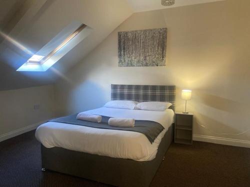 - une chambre mansardée avec un grand lit dans l'établissement Alexander Apartments North Shields, à South Shields