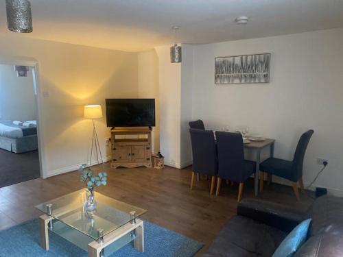 a living room with a couch and a table and a television at Alexander Apartments North Shields in South Shields