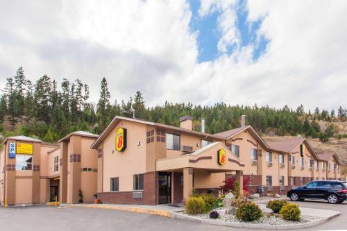 a hotel with a car parked in a parking lot at Super 8 by Wyndham Kamloops On The Hill in Kamloops