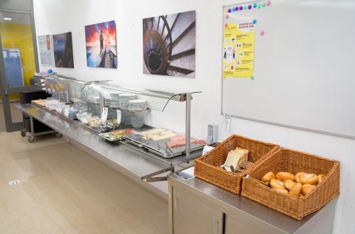 a buffet line with a basket of food on a counter at Jugend- und Familiengästehaus Villach in Villach