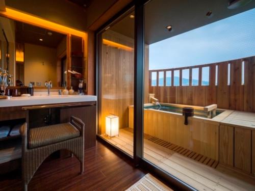 a bathroom with a tub and a balcony with a view at Bessho Sasa in Fujiyoshida