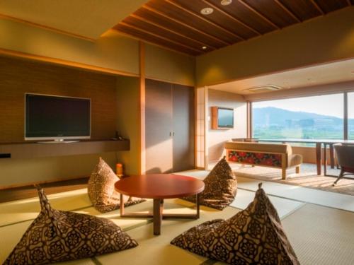 a living room with a table and chairs and a television at Bessho Sasa in Fujiyoshida