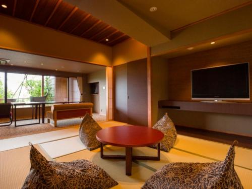 a living room with a television and a table and chairs at Bessho Sasa in Fujiyoshida
