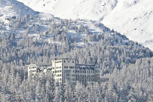 a building on the side of a snowy mountain at Hotel Waldhaus Sils in Sils Maria
