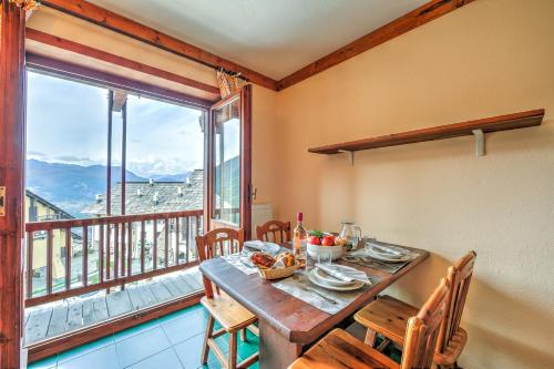 una sala da pranzo con tavolo e una grande finestra di Grange Hike & Ski Sestriere Apartments - Happy.Rentals a Sestriere