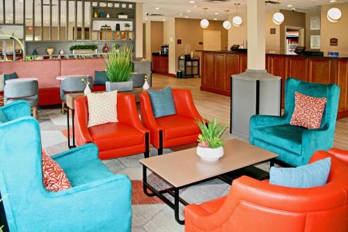 Comfort Inn & Suites Crestview في كرستفيو: لوبي وكراسي برتقالية وزرقاء وطاولة