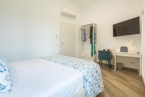 a bedroom with a bed and a desk and a television at Sorrento Tower in Sorrento