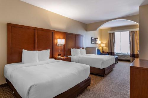 a hotel room with two beds and a balcony at Comfort Suites Houston near Medical Center- NRG Stadium in Houston