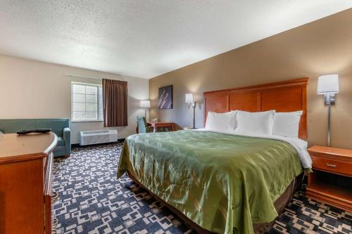 Redgranite的住宿－Quality Inn，配有一张床和一张书桌的酒店客房