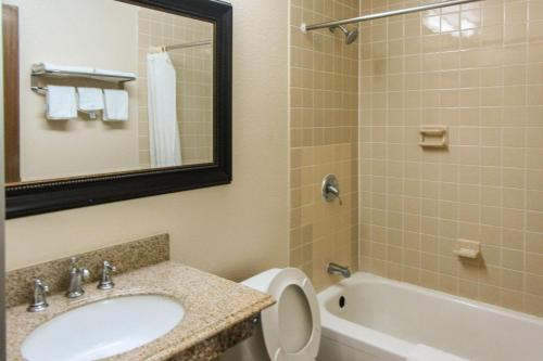 a bathroom with a sink and a toilet and a tub at Rodeway Inn in Zanesville