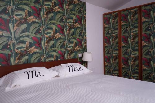 1 cama con 2 almohadas monogramadas encima en Loft moderno ubicato nel centro storico di Lucca, en Lucca