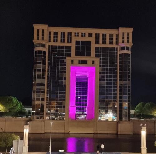 a building with a pink door in front of it at Kyriad Hotel Montpellier Centre Antigone in Montpellier