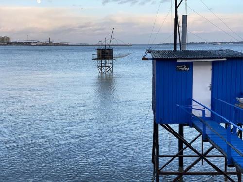 a blue building in the water next to the ocean at St Nazaire Jardin des plantes superbe appartement in Saint-Nazaire