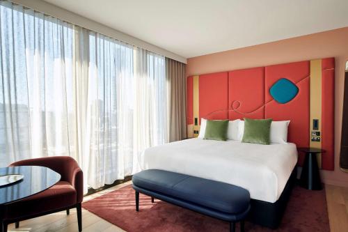 a hotel room with a large bed and a table at Quincy Hotel Melbourne in Melbourne