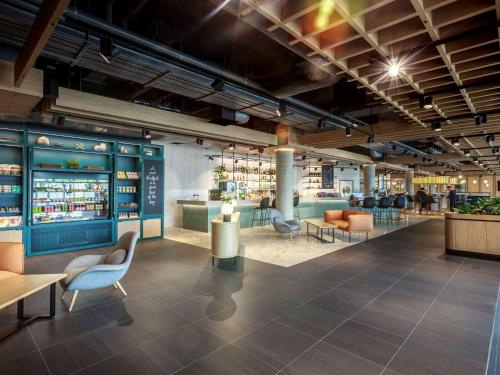 a lobby of a store with chairs and tables at Novotel Cambridge North in Cambridge