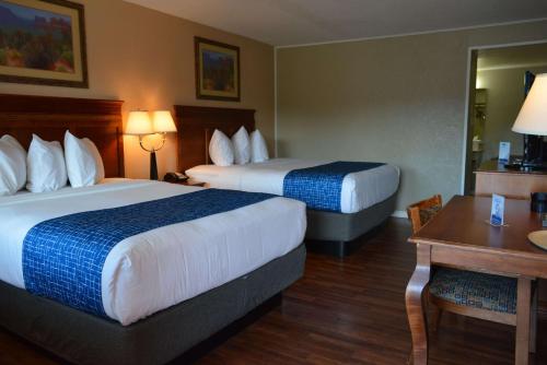 a hotel room with two beds and a table at Travelodge by Wyndham Trinidad in Trinidad