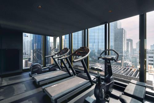 a gym with several tread machines in a building at Quincy Hotel Melbourne in Melbourne