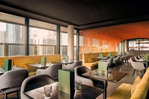 a restaurant with tables and chairs and large windows at Quincy Hotel Melbourne in Melbourne