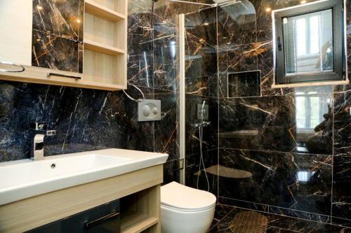 a black marble bathroom with a sink and a toilet at Villa-Sleeps 9-Parking-Pool-Bbq-Hot tub-Pets in Dalyan