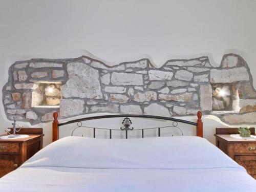 a bedroom with a bed with a stone wall at House Bruna in Kršan