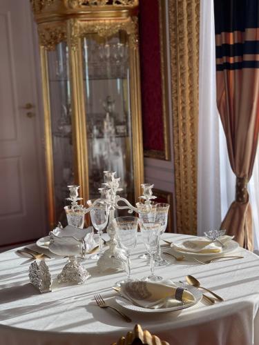 a table with a white table cloth and glasses on it at President Luxury in Ploieşti