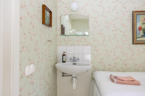 a bathroom with a sink and a mirror at Mormors Pensionat Strandhagen in Stora Rör
