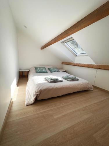 a bedroom with a bed in a attic with a window at Charmante Maisonnette au calme / Jardin privatif in Clermont