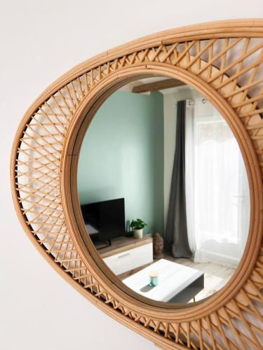 a large wooden mirror hanging on a wall at Charmante Maisonnette au calme / Jardin privatif in Clermont