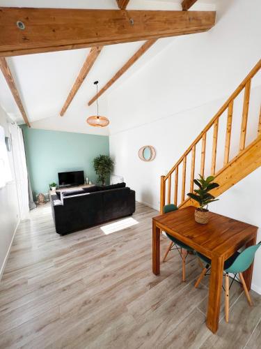 a living room with a wooden table and a couch at Charmante Maisonnette au calme / Jardin privatif in Clermont