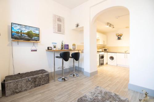 a living room with a counter and two stools at Elegant Central Exeter Apartment 5 min walk quay - Sleeps 4 in Exeter