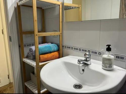 y baño con lavabo, espejo y toallas. en Apartamento Puente Romano con Parking gratuito, en Córdoba