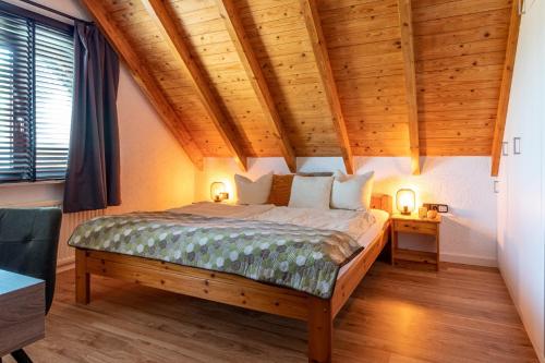 a bedroom with a large bed with wooden ceilings at Bergzicht in Schwalefeld