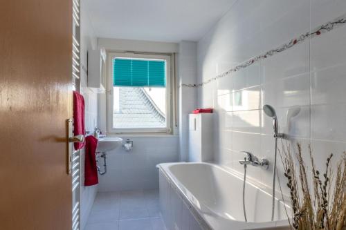 a bathroom with a tub and a sink and a window at Bödefeld in Schmallenberg