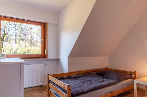 Cama en habitación con ventana en Bödefeld en Schmallenberg