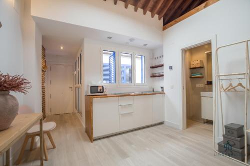 cocina con armarios blancos y encimera en Living4Malaga Skyline Apartments, en Málaga
