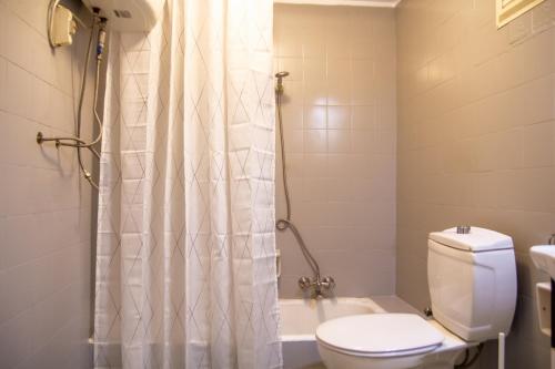a bathroom with a toilet and a shower curtain at Flat with Sea View near Karsiyaka Coast in Izmir