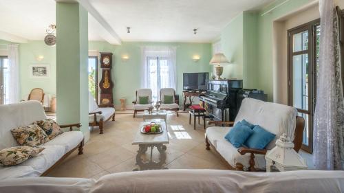 uma sala de estar com dois sofás e um piano em VILLA CAPPELLETTI 12, Emma Villas em Cese