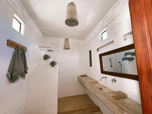 a bathroom with a tub and a sink and a mirror at Lamu penthouse Apartment in Lamu