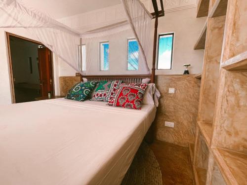 a bed in the back of a room with windows at Lamu penthouse Apartment in Lamu