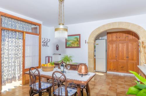 a kitchen with a table and chairs and a door at Es Pujols in Campanet