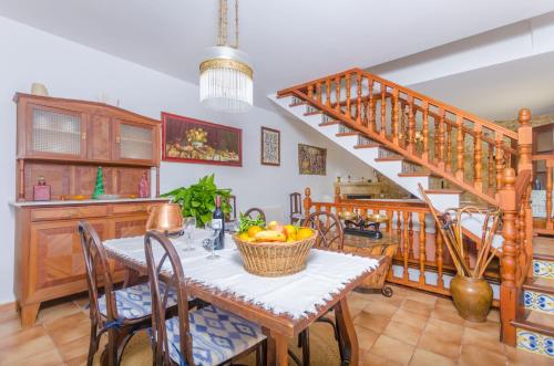a dining room with a table with a basket of fruit at Es Pujols in Campanet