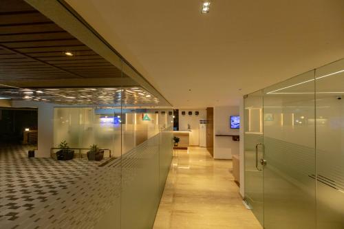 hol biurowy ze szklanymi ścianami i korytarzem w obiekcie Hotel Inland Avenue w mieście Mangaluru