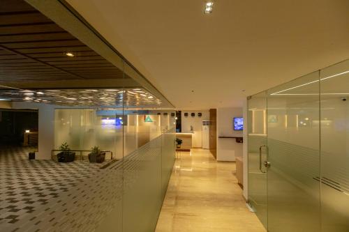 an office lobby with glass walls and a hallway at Hotel Inland Avenue in Mangalore