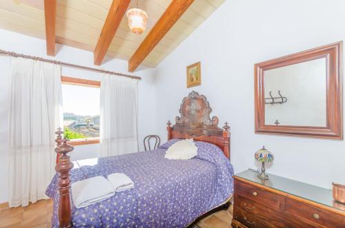 a bedroom with a bed with a mirror and a dresser at Es Pujols in Campanet