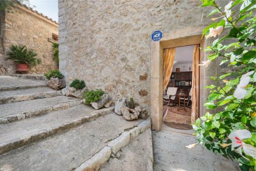 a stone building with stairs leading to a door at Es Pujols in Campanet